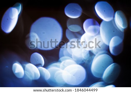 Beautiful vintage abstract background with christmas lights in boken. Old filmphoto effect. Amazing retro texture for design. Blue light blurred.
