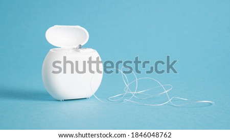 Container with dental floss. Floss on blue background. White dental floss case isolated. Open dental floss container Royalty-Free Stock Photo #1846048762