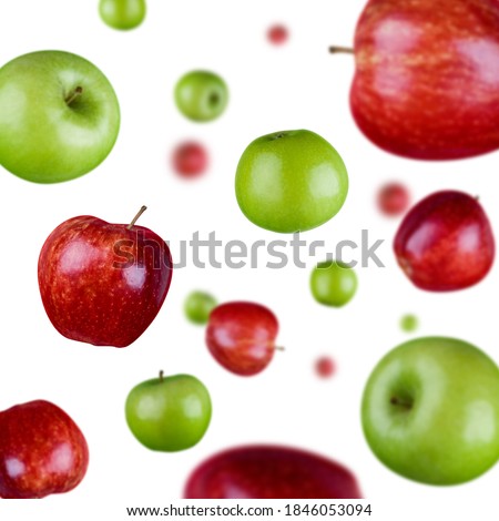 Many green and red apples freefalling on white background. Selective focus - shallow depth of field.