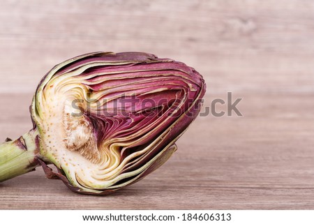 fresh exotic purple artichoke on wooden background