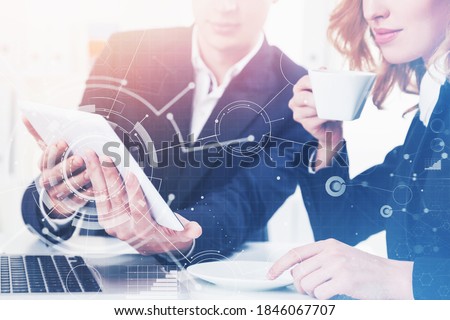 Businessman and businesswoman working together in office with double exposure of network interface. Toned image