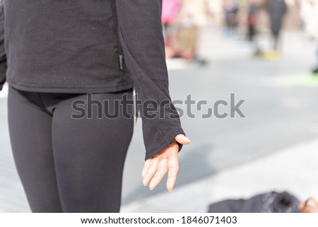 Yoga teachers protesting against the blockade and restrictions of Covid-19 in a square in Brescia, Italy. Detail of the hand of a woman who is standing in the mountain position.