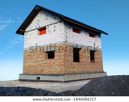 Unfinished house against the blue sky. Building a house. Stock photo.