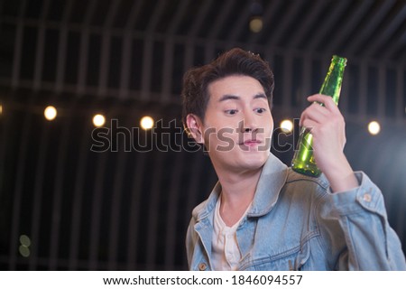 Young man holding beer bottles drinking beer drunk, Hangover