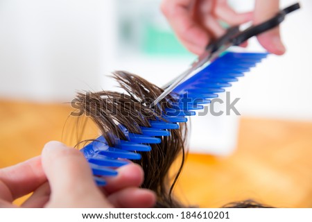 hairdresser cutting wet hair close-up, beauty salon