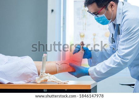 close-up hand wear medical gloves doctor in medical gloves holds artificial boneof the foot and examines a sore ankle in clinic, Concept of medical orthopedic treatment Royalty-Free Stock Photo #1846147978