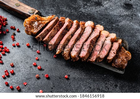 Grilled marbled beef steak. Black background. Top view