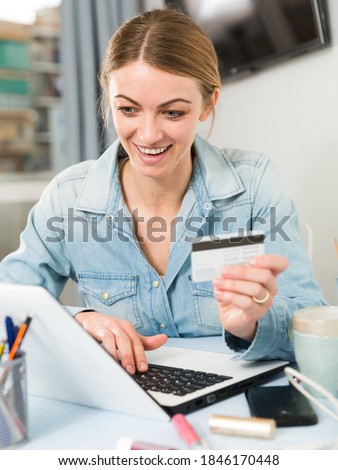 Girl buying online with laptop and credit card at home. High quality photo