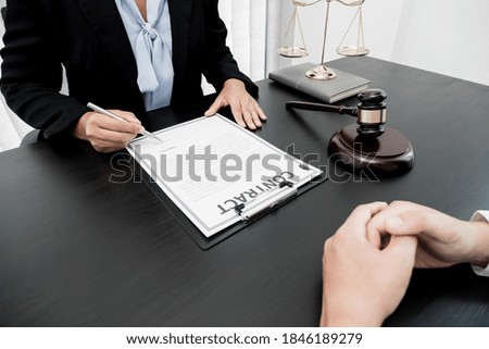 A woman lawyer or a judge counseling clients about judicial justice and prosecution with scales, judges gavel, legal documents legal services concept.