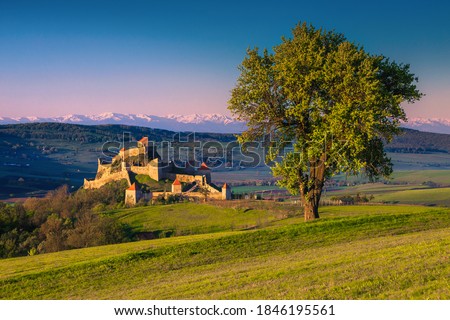 Amazing morning scenery with Rupea fortress and snowy mountains in background. Great touristic and excursion place, Transylvania, Romania, Europe