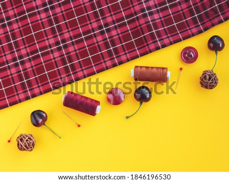 Top view on cloth and sewing kits on yellow background. Flat lay concept of hand craft with copy space