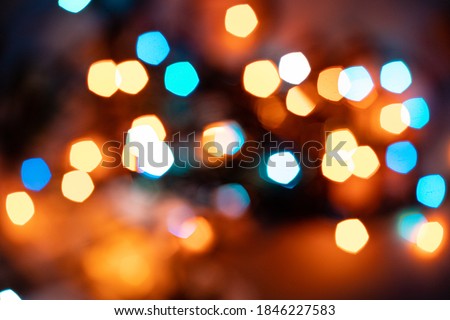 Blurry colored lights on a dark background. Bokeh style. New Year and Christmas background.  Soft focus