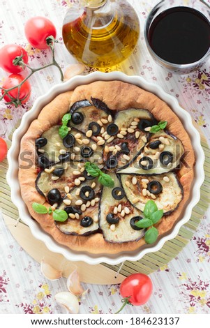 Vegetarian pie with eggplants, olives and pine nuts