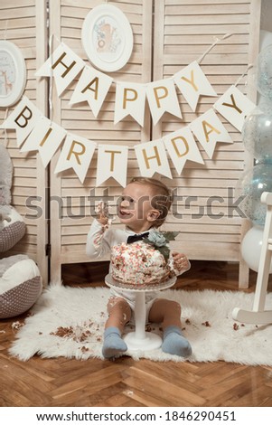 Baby 1st birthday theme. Baby eating cake isolated.