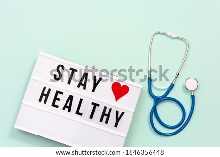 Healthcare and medical concept. Lightbox with words Stay Healthy and stethoscope on blue colored background. Health wishes. Top view.