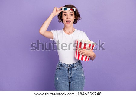 Photo portrait of girl smiling holding pop-corn box taking off 3d glasses watching movie cinema isolated on vibrant purple color background Royalty-Free Stock Photo #1846356748