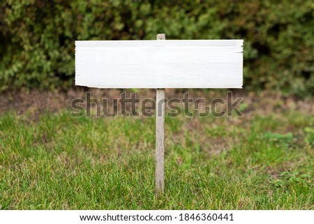 Blank mock up wooden sign in the garden. Concept for advertisement, guide board, tourism wood sign.