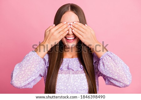 Photo of charming smiling teen girl wear casual purple outfit arms cover eyes isolated pastel pink color background