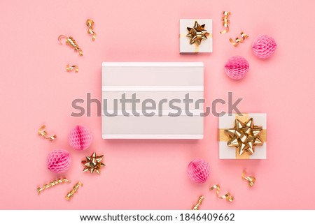 Empty white Lightbox with festive gift boxes, golden and pink decorations on amaranth pink paper background. Christmas, new year, birthday concept. Flat lay, top view, copy space.