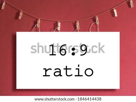 Fixed 16:9 mockup screen hanged on a clothesline. Red / magenta wall background. Royalty-Free Stock Photo #1846414438