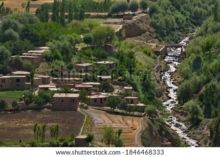 Central Asia. Afghanistan. Huts made of clay and stone in a mountain village on the left coast of the border river Panj. Royalty-Free Stock Photo #1846468333