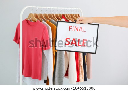 Clothes on the rail and a sale sign. Final sale, discounts