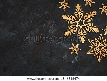 Christmas or New Year dark wooden background, Xmas black board framed with season decorations, space for a text. Christmas Background - Gold Snowflakes On dark background. Golden snowflakes. 