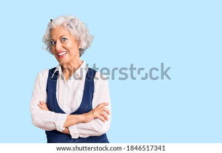 Senior grey-haired woman wearing casual clothes happy face smiling with crossed arms looking at the camera. positive person. 