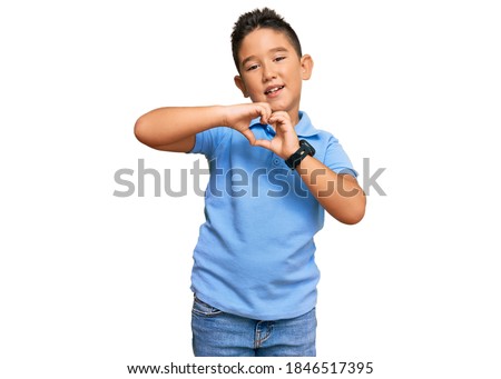 Little boy hispanic kid wearing casual clothes smiling in love doing heart symbol shape with hands. romantic concept. 