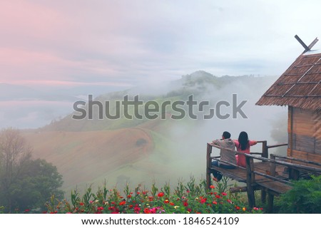 Roman picture at the hut on the cliff  morning scenery with flower and fog at Nan province, Thailand