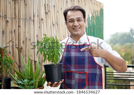 Man in apron doing gardening at home                