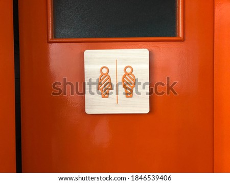 unisex bathroom with orange door
