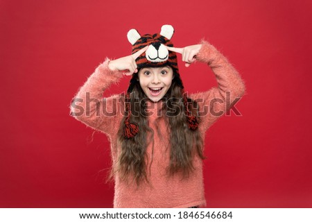 look at this. winter kid fashion. happy childhood. christmas time activity. holiday fun. cold season accessory. cheerful child in warm clothing. stylish teen girl with long hair in earflaps.