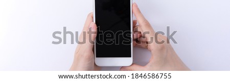 female hands holding new modern black smartphone isolated on white background, close view . High quality photo