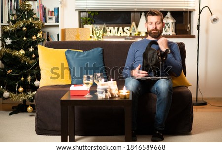 man with cat celebrating Christmas at home social distancing