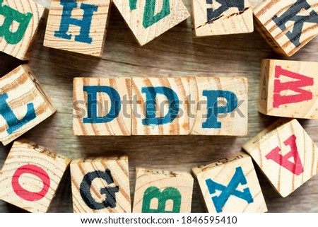 Alphabet letter block in word DDP (Abbreviation of Delivered duty paid) with another on wood background