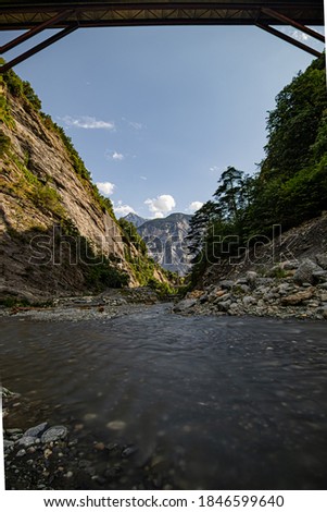 River flowing through valley on a sunny summer day. Switzerland