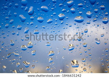 Rain drops on the glass. Abstract background photo. Natural pattern close up. Selective focus.