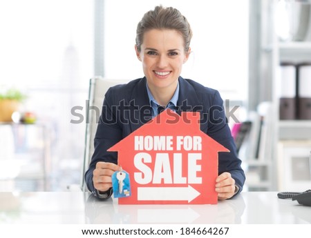 Realtor woman showing keys and home for sale sign