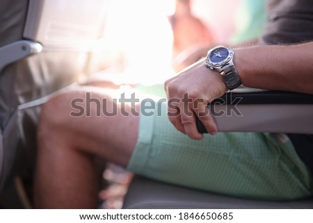 Man is sitting in an airplane seat and holding on to armrest. Aviophobia and the reasons for the fear of flying an airplane concept Royalty-Free Stock Photo #1846650685