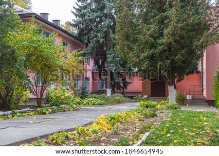 
The facade is pink among autumn trees.