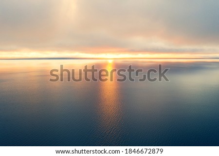 Aerial view of a sunset sky background. Aerial Dramatic gold sunset sky with evening sky clouds over the sea. Sky landscape. Aerial photography.