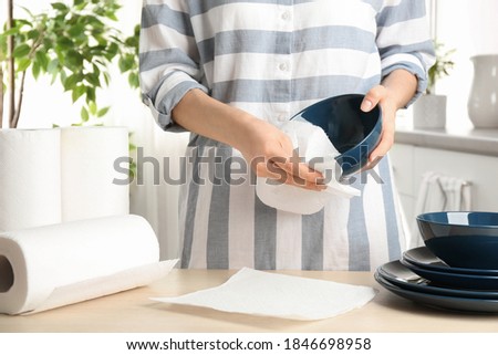 Woman wiping ceramic bowl with paper towel indoors, closeup Royalty-Free Stock Photo #1846698958