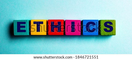 The word ETHICS is written on multicolored bright wooden cubes on a light blue background