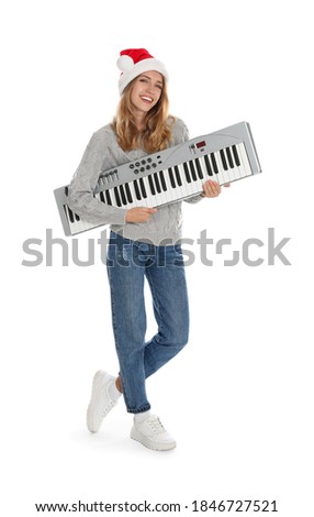 Young woman in Santa hat with synthesizer on white background. Christmas music