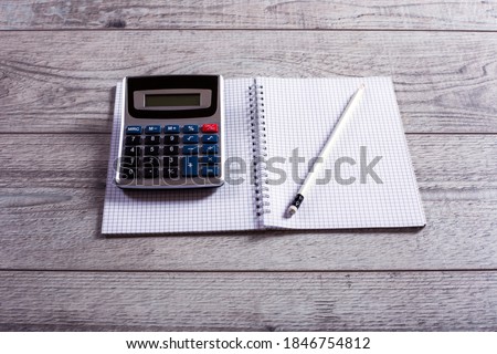 Open notebook with pen and calculator  in studio