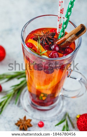 Hot tea with orange slices and cranberries in glass tall glasses. Hot drinks for winter and Christmas. Close up
