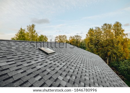 new renovated roof covered with shingles flat polymeric roof-tiles Royalty-Free Stock Photo #1846780996