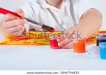 Brush and paint in the hand of a young artist