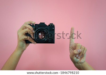 Old camera in female hands on a pink background Royalty-Free Stock Photo #1846798210